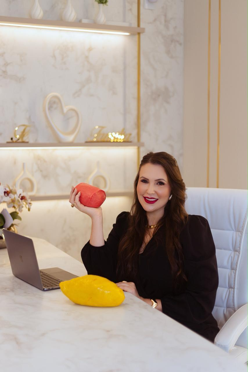 Danielle em seu consultório, com bancada em mármore, poltrona e prateleiras iluminadas